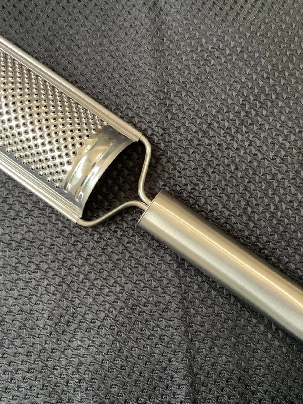 Stainless handled grater also has hole for hanging.   8-1/4” long & 1-5/8” wide.